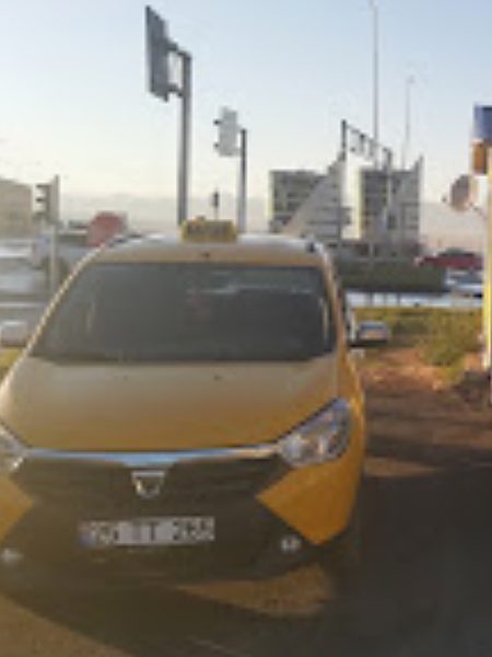Trafik ışıkları önünde bekleyen sarı taksi